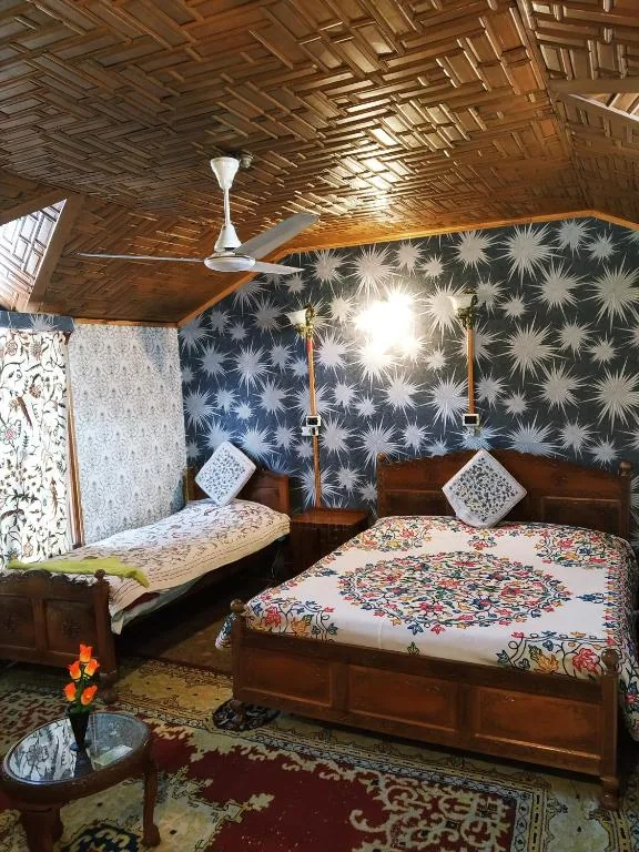 Deluxe bedroom with carved wooden bed and Kashmiri crewel furnishings