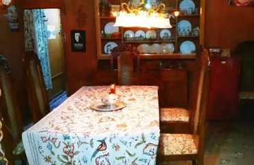 Dining table laid with crewel linen